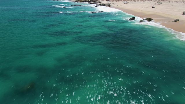 Waves Breaking on Rocky Beach with Clear Turquoise Water