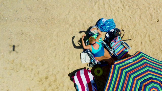 Beachgoer Relaxing and Leaving a Sandy Shore