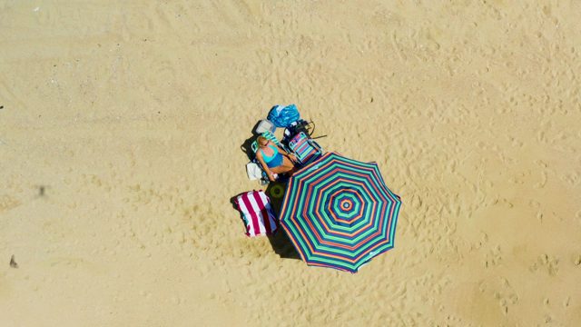 Overhead View of Person Under Beach Umbrella