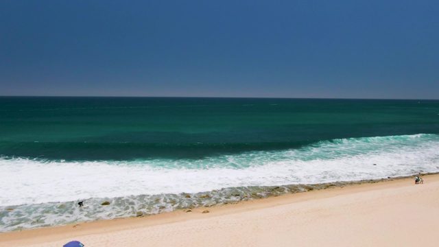 Waves Advancing Toward Sandy Shore on Beach