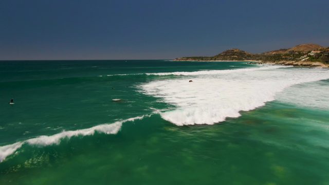 Waves Breaking in Clear Turquoise Ocean with Swimmers
