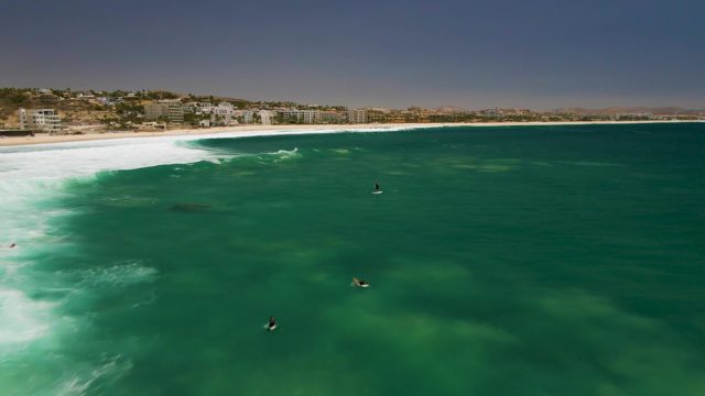 Surfers Riding Ocean Waves From Above