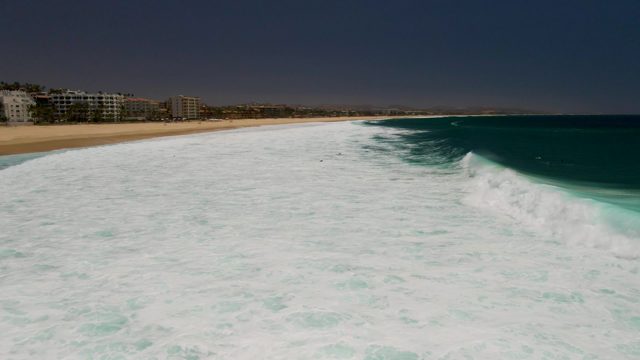 Waves Breaking on Sandy Shore From Aerial View