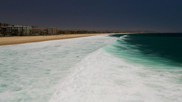 People Swimming in Ocean Waves at Sandy Beach