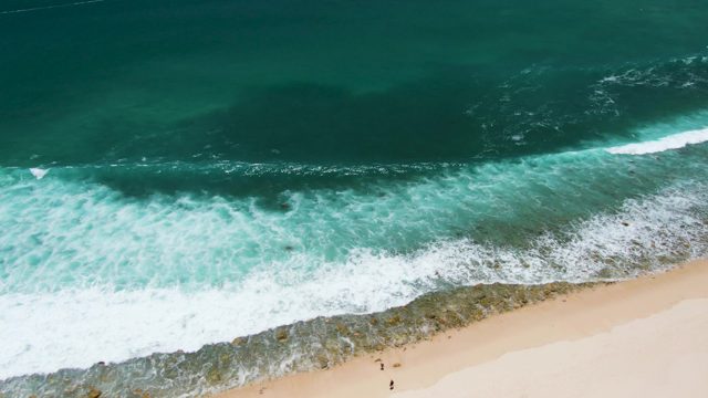 Ocean Waves Rolling Onto Sandy Beach From Above