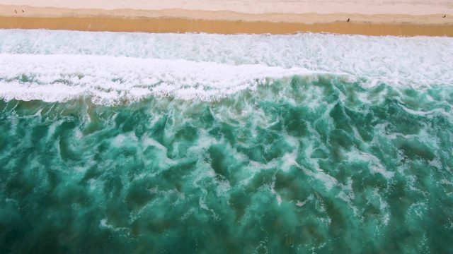 Waves Rolling In On Sandy Shore