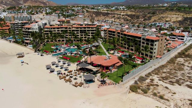 Beachfront Hotel with Guests Moving on Sandy Shore