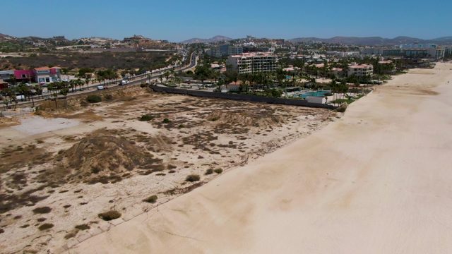 Sandy Dunes, Beach, and Coastal Road with Buildings