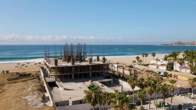 Beachside Construction Site with Ocean and Palm Trees