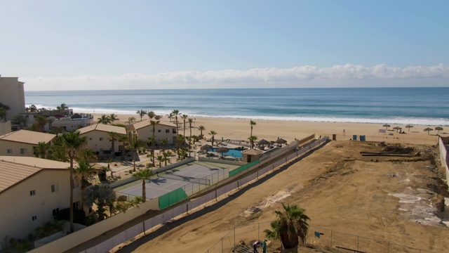 Beachside Construction Site with Palm Trees and Ocean
