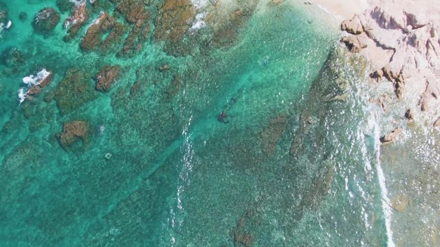 Clear Turquoise Water Lapping Rocky Shore