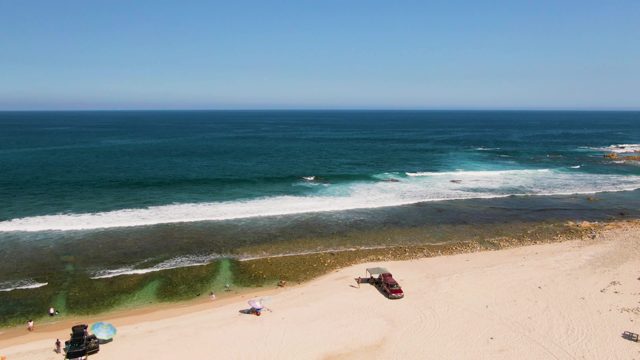 Waves Rolling on Sandy Beach with Moving Vehicle