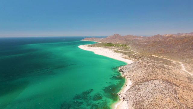 Coastal Beach with Turquoise Waters and Rocky Hills