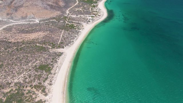 Sandy Coastline with Turquoise Waters and Rocky Terrain