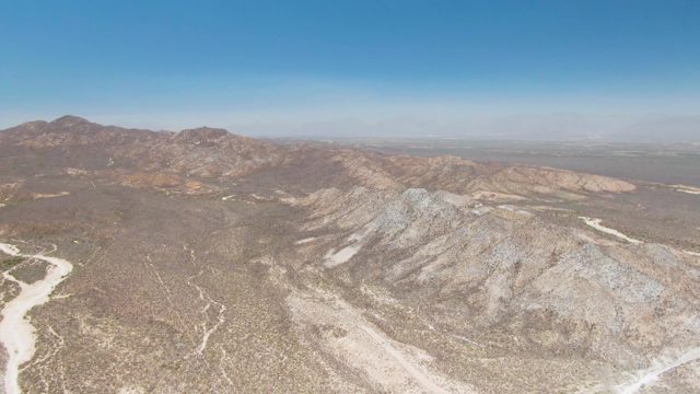 Arid Desert Landscape with Mountain Ridges and Dry Wash