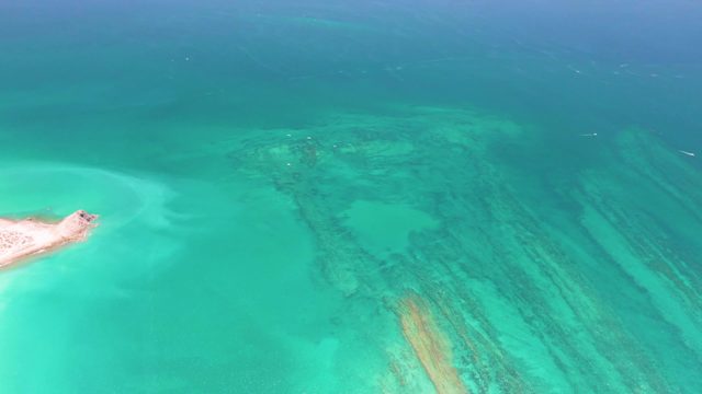 Small Sandy Island in Shallow Turquoise Water