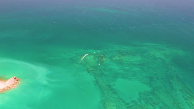 Sandy Islet and Coral Reef in Clear Turquoise Water