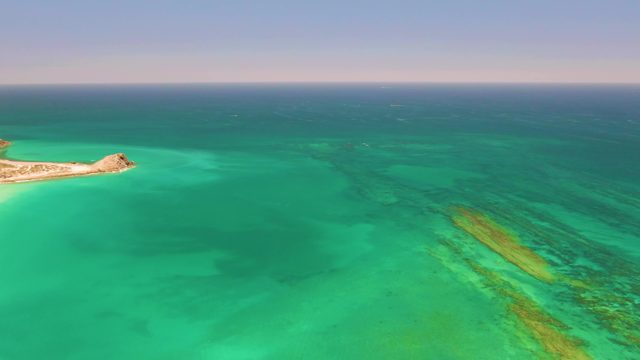 Small Island and Clear Turquoise Ocean Waters