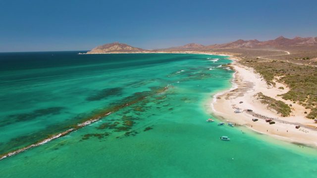 Sandy Beach with Turquoise Water and Moving Boats