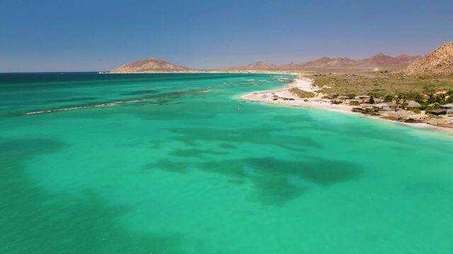 Coastal Waters with Sandy Shore and Mountain Backdrop