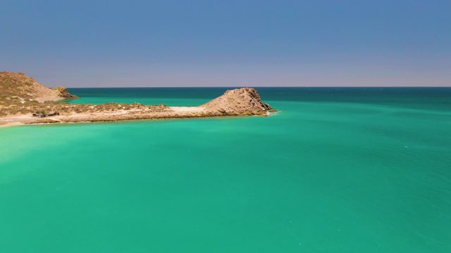 Rocky Peninsula with Turquoise Waters and Sandy Shore