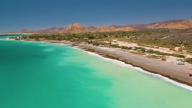 Cars Departing Sandy Beach with Turquoise Water