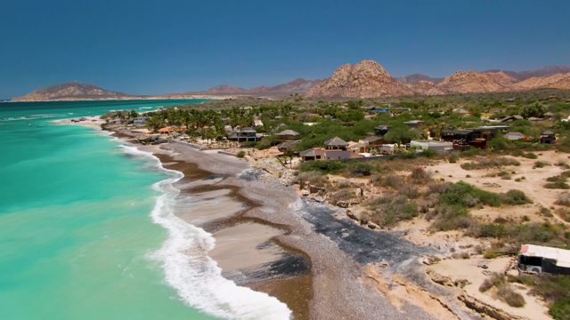 Beach with Turquoise Water and Moving Vehicles