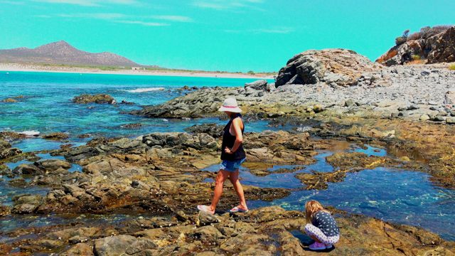EL SARGENTO LA VENTANA MEXICO-2020: Two People Exploring Rocky Coastal Shore with Clear Water