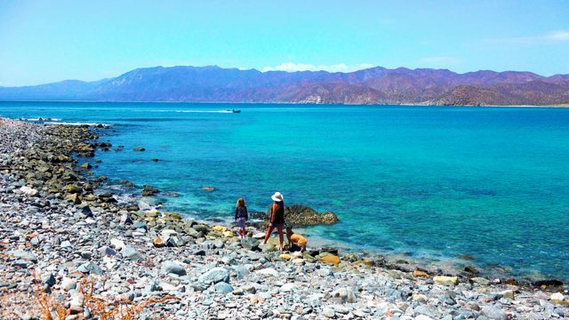 EL SARGENTO LA VENTANA MEXICO-2020: Rocky Shore with People, Dog, and Passing Boat