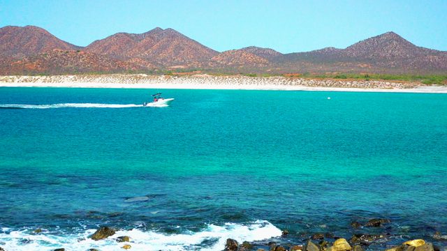 EL SARGENTO LA VENTANA MEXICO-2020: Speedboat Gliding on Turquoise Waters Near Rocky Shore