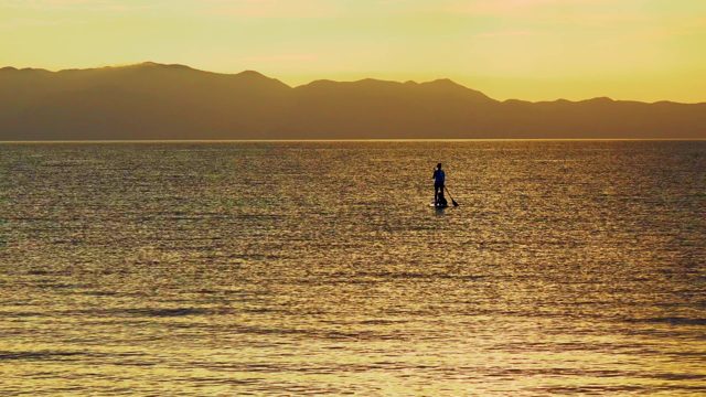 EL SARGENTO LA VENTANA MEXICO-2020: Silhouetted Paddleboarder Gliding on Calm Ocean at Sunset