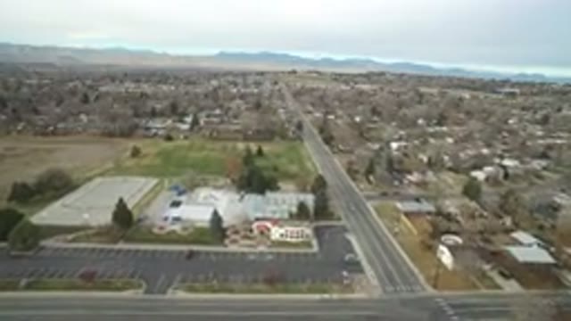 WESTMINSTER COLORADO-2016: Drone Approaching A City With Mountains In The Background