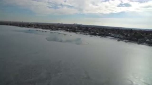 HIDDEN LAKE COLORADO-2016: Aerial View Of A Frozen Lake In Front Of A Snowy