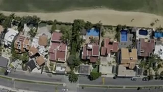LOS CABOS MEXICO-2019: A Camera Viewing A Neighborhood Full Of Houses And A Busy Street
