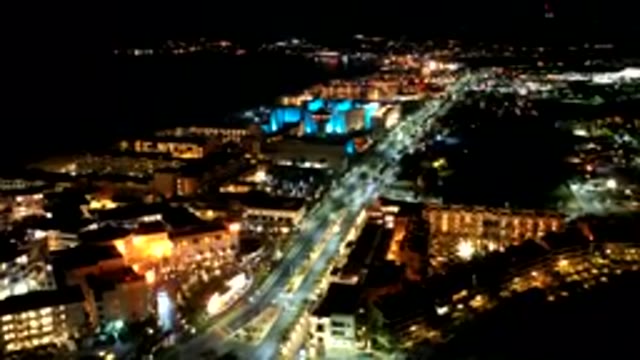 LOS CABOS MEXICO-2019: Cars Zoom Down Highway In Bright Downtown City At Night