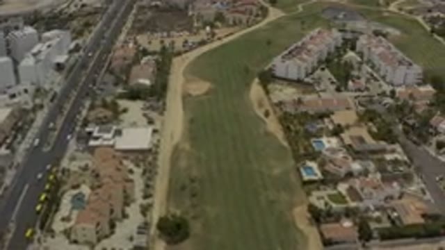 LOS CABOS MEXICO-2019: Overhead View Of Long Green Field And Traffic On Highway