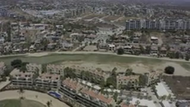 LOS CABOS MEXICO-2019: Buildings Built On Hills Between Green Lawn In A