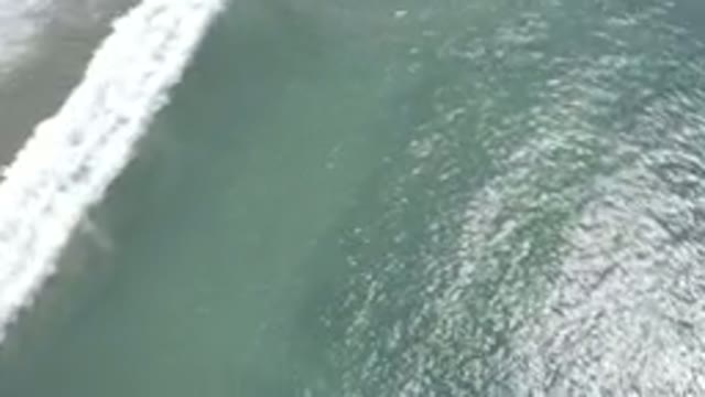 LOS CABOS MEXICO-2019: Aerial View of Green Ocean Waves Gently Breaking on a Beach