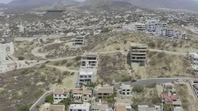 LOS CABOS MEXICO-2019: Buildings On The Edge Of A Sandy Hill With Undergrowth