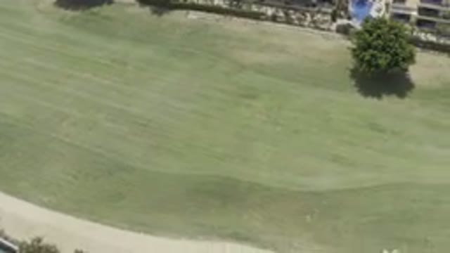 LOS CABOS MEXICO-2019: Boring Fly Over Of Green Mowed Field With A Dirt Road Or