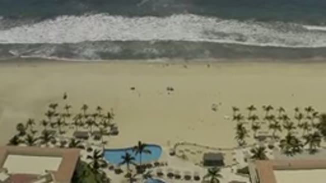 LOS CABOS MEXICO-2019: Waves Crash On Sandy Shore Of Beautiful Beach With Trees