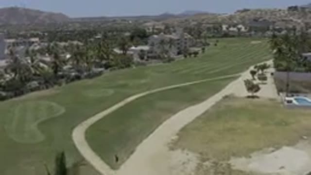 LOS CABOS MEXICO-2019: Camera Pans Over Grassy Area With Houses And Palm Trees