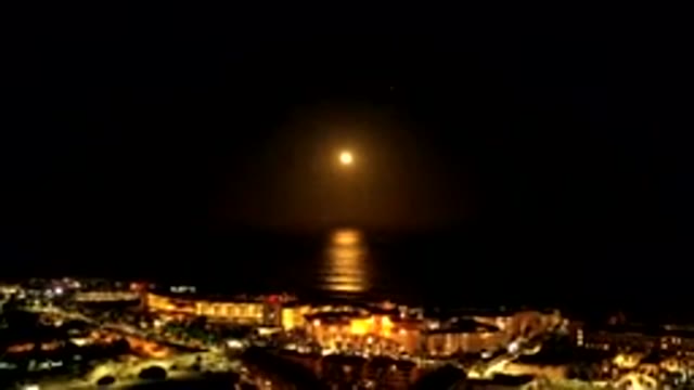 LOS CABOS MEXICO-2019: Dark Night Cityscape With Full Moon Reflecting on Water