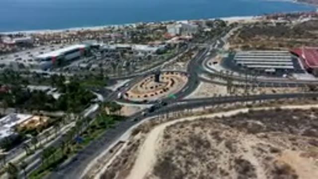LOS CABOS MEXICO-2019: Hi-Speed Video Of Cars Circling A Large Roundabout With Palm Trees