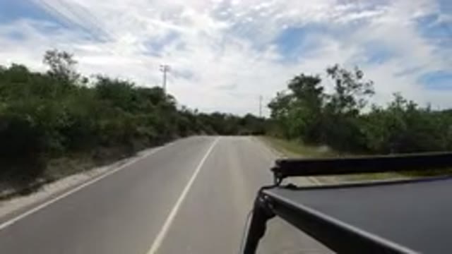 LOS CABOS MEXICO-2019: Car Cruising Down Open And Empty Road With Bushes To The Side