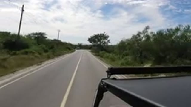 LOS CABOS MEXICO-2019: Car Driving Down Paved Road Passing Another Car