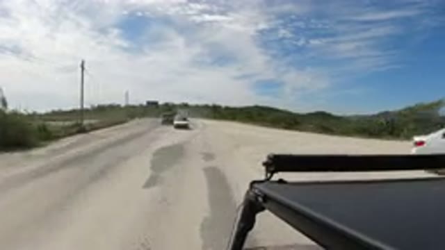 LOS CABOS MEXICO-2019: Car Speeds Past Other Cars Down Road Covered In Loose Sand