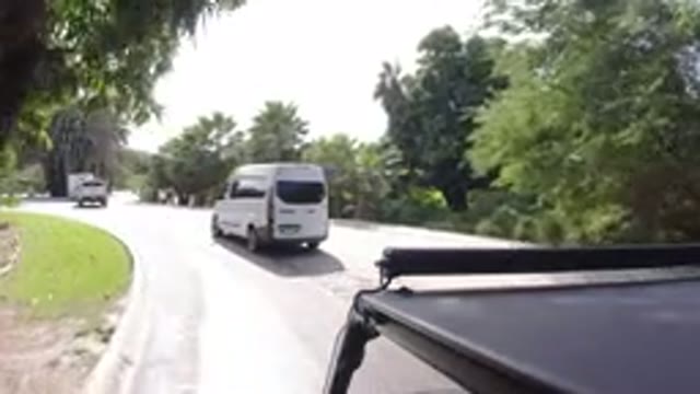 LOS CABOS MEXICO-2019: White Van Driving Down Street With Pedestrian