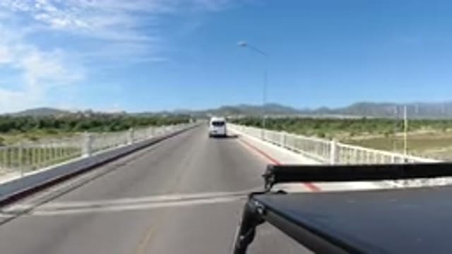 LOS CABOS MEXICO-2019: Black Car Drives Along Narrow Two-Lane Bridge Midst