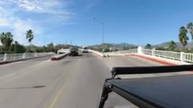 LOS CABOS MEXICO-2019: Driving Car On Two Way Road On A Bridge With Hills Around